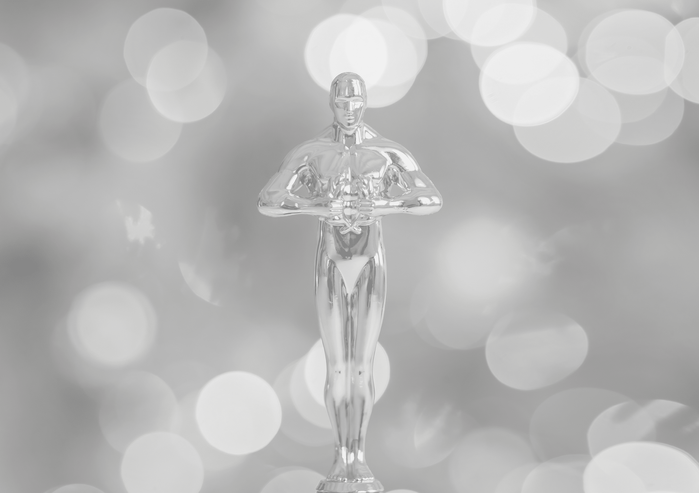Hollywood gold oscars trophy figurine imitation seen during an award cinema ceremony. Success and victory concept close up statuette at twinkle yellow lights background